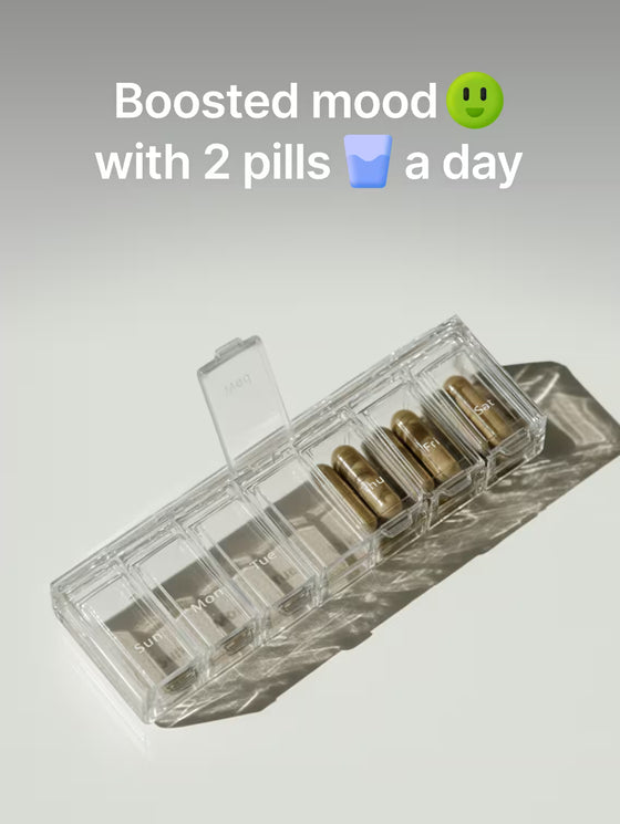 Clear pill organizer with two gold pills on a light gray background, text 'Boosted mood with 2 pills a day' above.